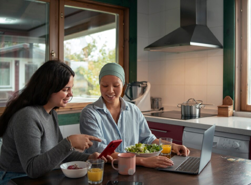 Smiling support worker and client in a tidy, sunlit kitchen after completing household chores